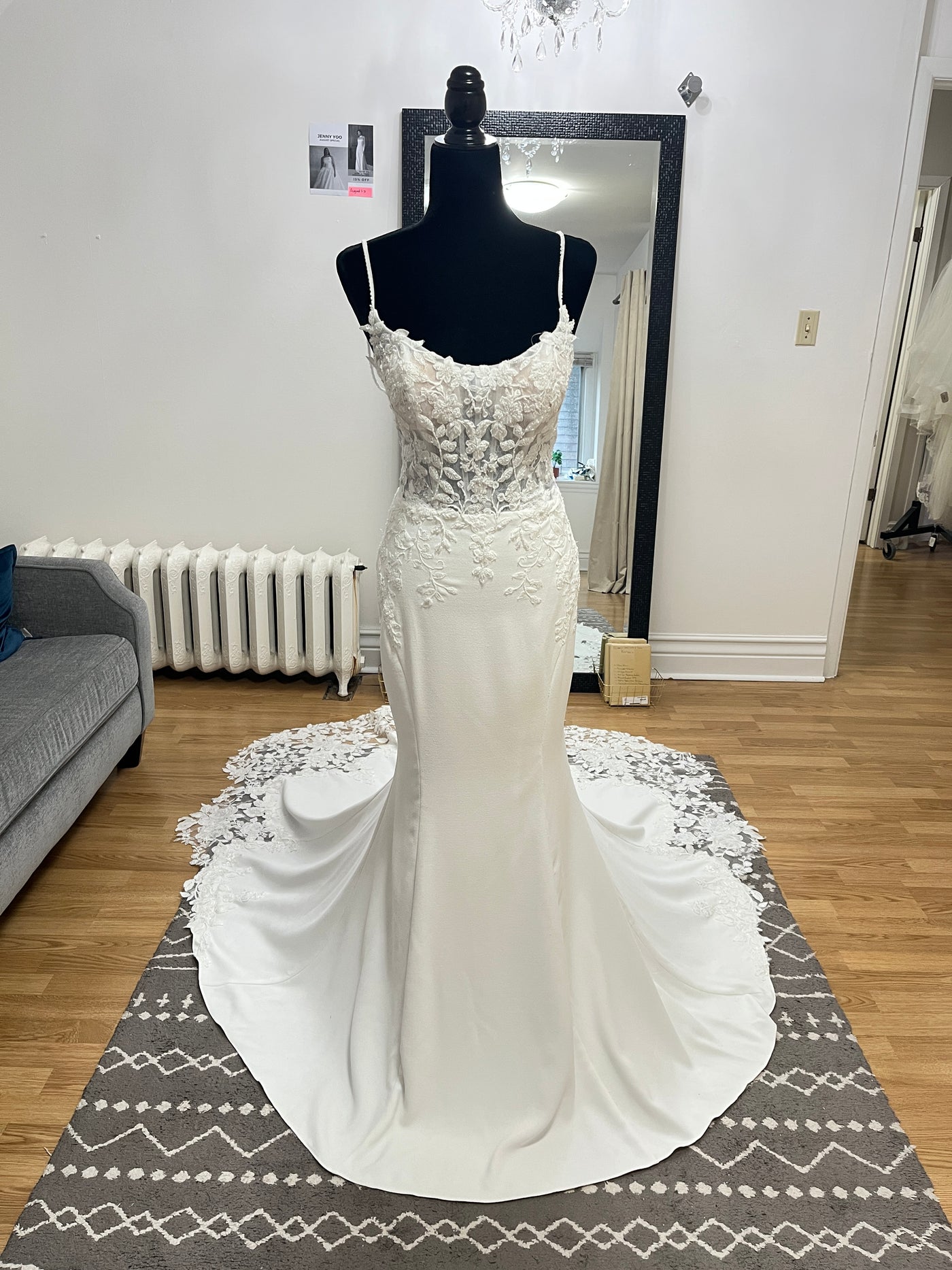 The Bergamot Bridal Crepe and Lace Fit & Flare Gown features a beaded lace bodice, beaded spaghetti straps, and a scalloped lace train, shown sleeveless on a black mannequin in a well-lit room with wooden floors.