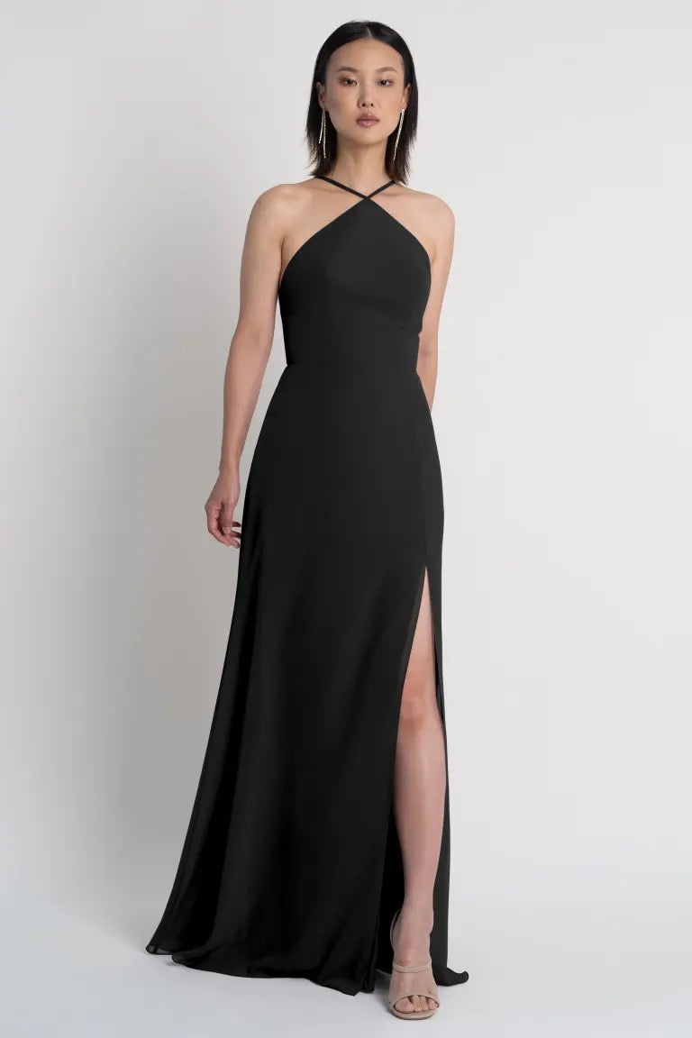 Woman posing in a black one-shoulder evening gown with a side slit, the Ingrid bridesmaid dress by Jenny Yoo from Bergamot Bridal.