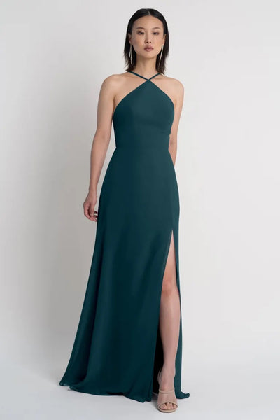 Woman in an elegant green Ingrid bridesmaid dress by Jenny Yoo with a side slit from Bergamot Bridal.