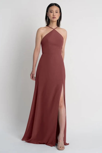 Woman in a sleeveless Ingrid bridesmaid dress by Jenny Yoo with a halter neckline and a high side slit from Bergamot Bridal.