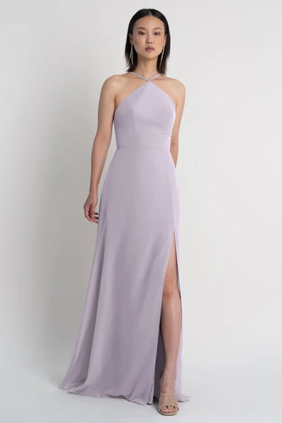 Woman posing in a light purple Ingrid bridesmaid dress by Jenny Yoo with a side slit from Bergamot Bridal.