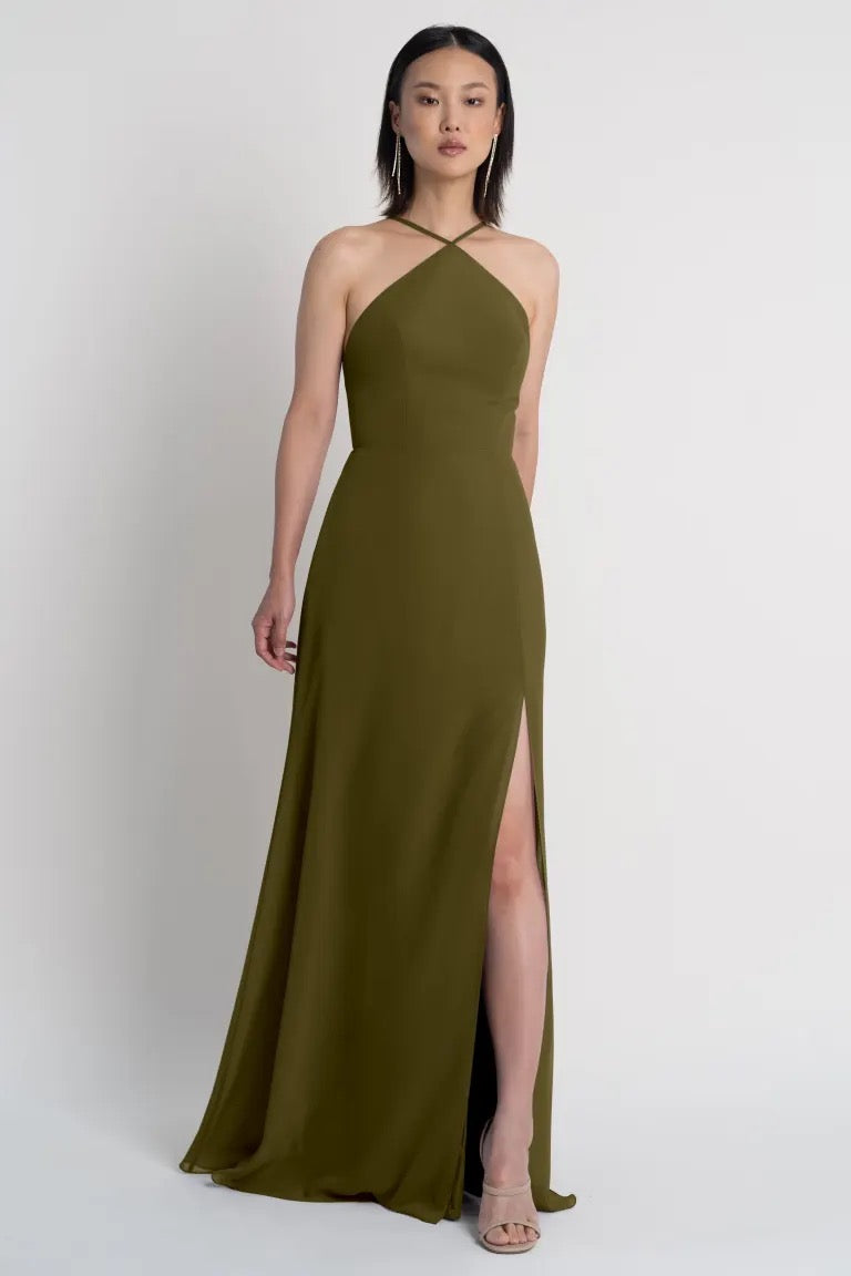 Woman posing in an olive green Ingrid bridesmaid dress by Jenny Yoo with a thigh-high side slit from Bergamot Bridal.