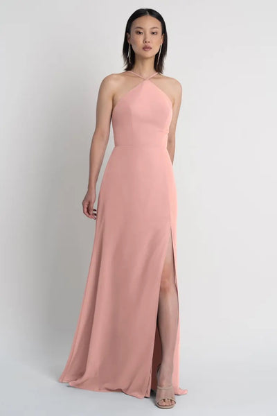 Woman modeling a Bergamot Bridal bridesmaid dress by Jenny Yoo featuring a halter neckline and a side slit.