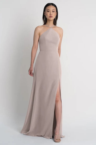 A woman in an elegant Ingrid bridesmaid dress by Jenny Yoo with a side slit from Bergamot Bridal.