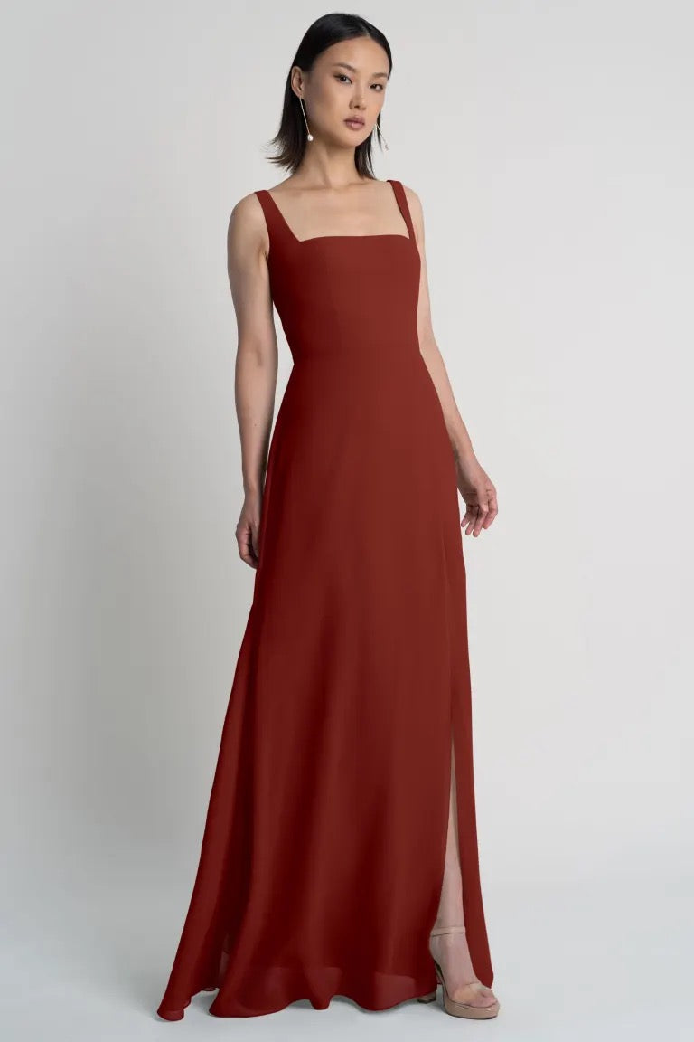 Woman posing in a Jenna - Bridesmaid Dress by Jenny Yoo in burgundy by Bergamot Bridal with a square neckline.