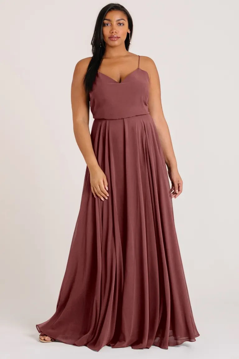 A woman wearing a Inesse bridesmaid dress by Jenny Yoo with a long, flowing maroon circle skirt from Bergamot Bridal.