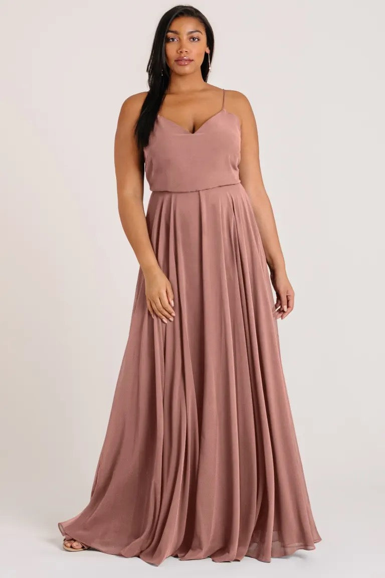 Woman in an elegant rose-colored Inesse V-neck maxi dress by Jenny Yoo from Bergamot Bridal.