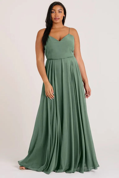 Woman in an elegant green Inesse bridesmaid dress by Jenny Yoo, available at Bergamot Bridal.