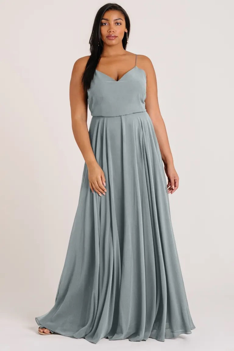 Woman in an elegant, sage green Inesse chiffon bridesmaid dress by Jenny Yoo with a V-neck from Bergamot Bridal.