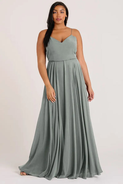 Woman posing in a Inesse bridesmaid dress by Jenny Yoo with a V-neck and spaghetti straps from Bergamot Bridal.