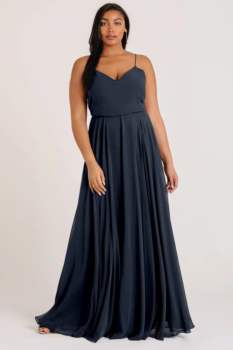 Woman posing in an elegant Inesse chiffon bridesmaid dress by Jenny Yoo with a V-neck from Bergamot Bridal.