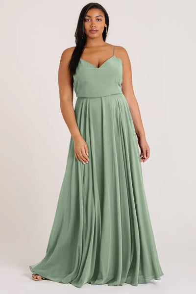Woman in an elegant sage green Inesse chiffon bridesmaid dress by Jenny Yoo with a V-neck from Bergamot Bridal.