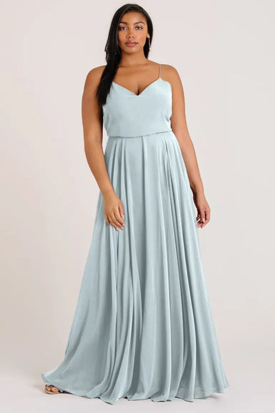 Woman posing in a light blue Inesse chiffon bridesmaid dress by Jenny Yoo with a V-neck from Bergamot Bridal.