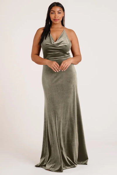 Woman in an elegant Sullivan velvet bridesmaid dress by Jenny Yoo with a halter cowl neckline posing for the camera from Bergamot Bridal.