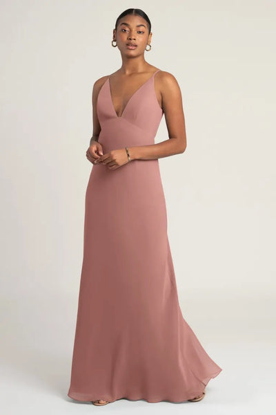 Woman posing in an elegant dusty rose chiffon slip bridesmaid dress, the Jude by Jenny Yoo from Bergamot Bridal.