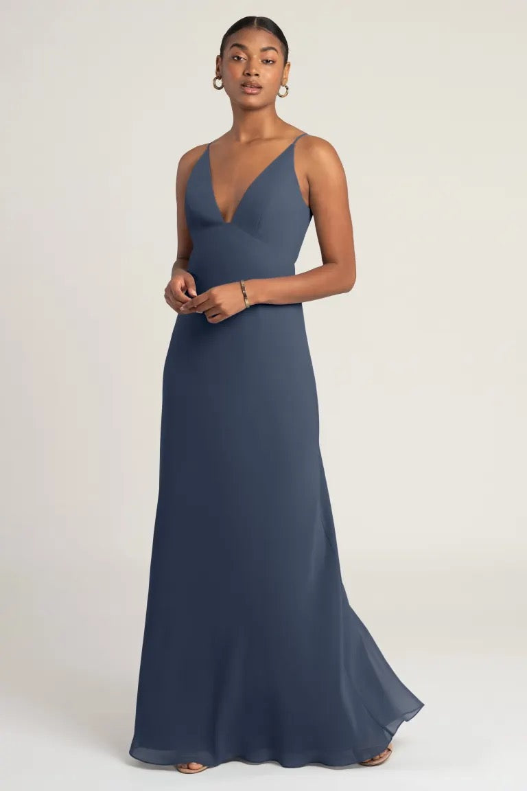 Woman in an elegant navy blue Jude - Bridesmaid Dress by Jenny Yoo with an empire waist from Bergamot Bridal.