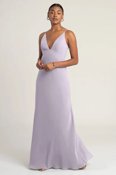 A woman in a "Jude - Bridesmaid Dress" by Jenny Yoo with an empire waist, posing for a photograph from Bergamot Bridal.