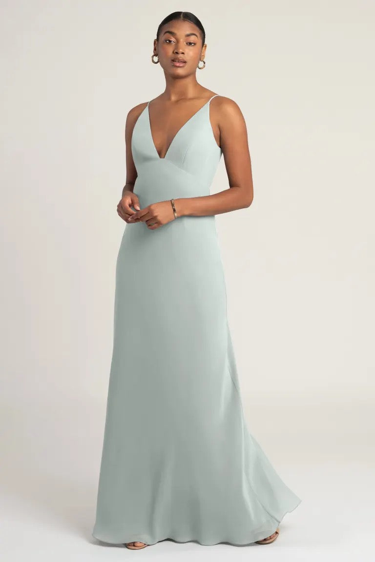 A woman in an elegant light blue chiffon slip bridesmaid dress, Jude by Jenny Yoo from Bergamot Bridal, posing for a photograph.