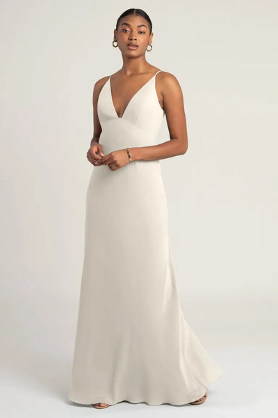 Woman in an elegant cream Jude - Bridesmaid Dress by Jenny Yoo gown with an empire waist posing for a photograph from Bergamot Bridal.