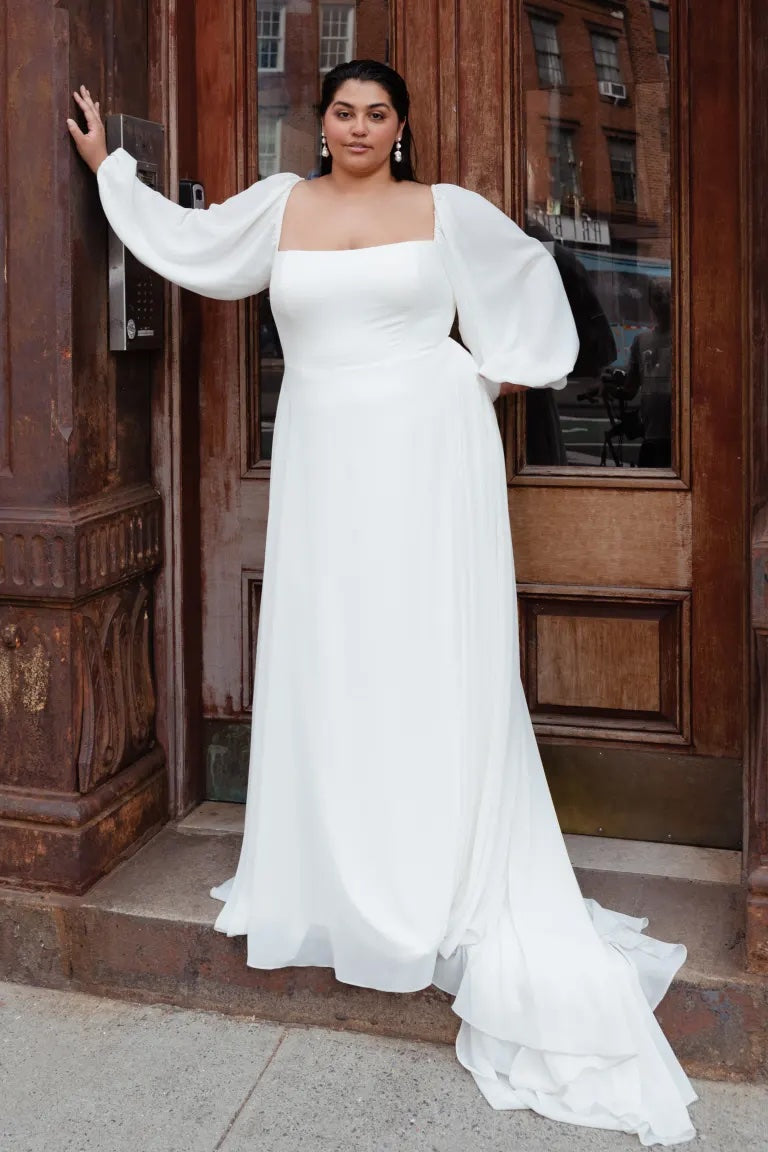 Woman in a white wedding dress with an A-line skirt posing by a wooden door. 
becomes 
Woman in a Louise - Jenny Yoo Wedding Dress with an A-line skirt posing by a wooden door.