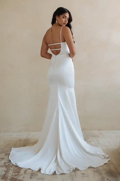 Woman in an elegant Lydia - Jenny Yoo Wedding Dress gown with an open back design and train from Bergamot Bridal.