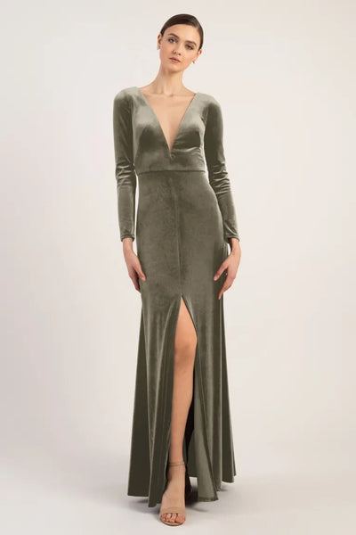 Woman posing in an elegant Luxe Velvet Malia bridesmaid dress with a slit by Jenny Yoo at Bergamot Bridal.