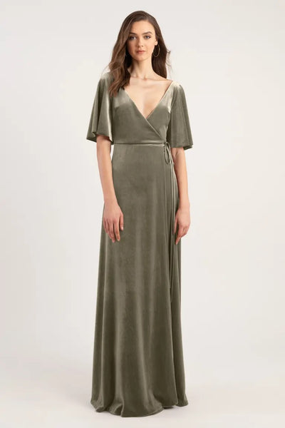 Woman modeling an olive green wrap-style Marin - Bridesmaid Dress by Jenny Yoo with short sleeves and a deep V-neckline from Bergamot Bridal.