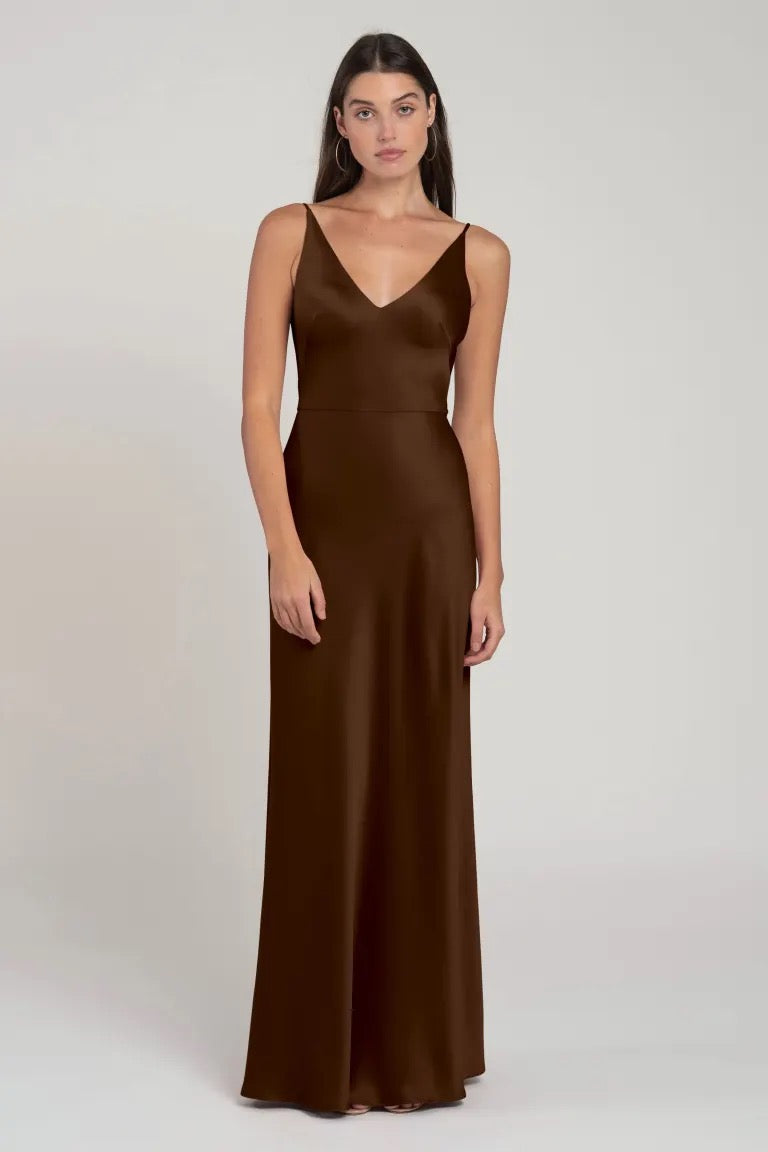 Woman modeling a sleeveless brown Marla bridesmaid gown by Jenny Yoo with a v-neckline from Bergamot Bridal.