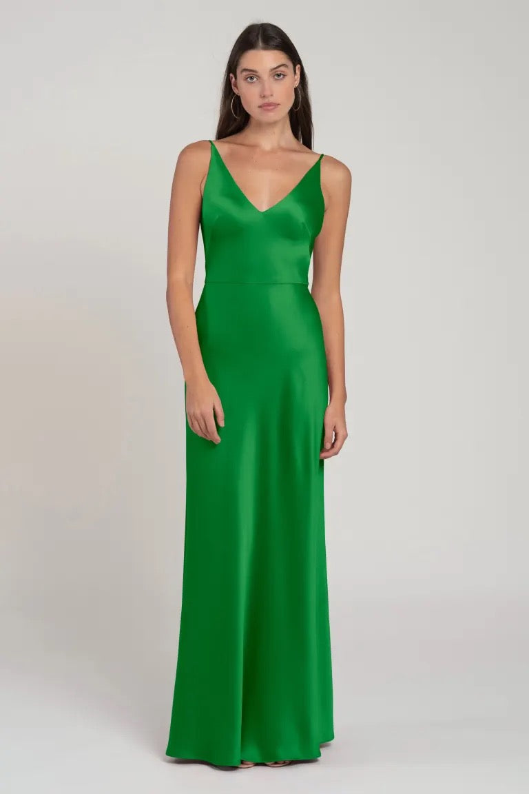 Woman modeling a green V-neck satin Marla bridesmaid dress by Jenny Yoo from Bergamot Bridal.