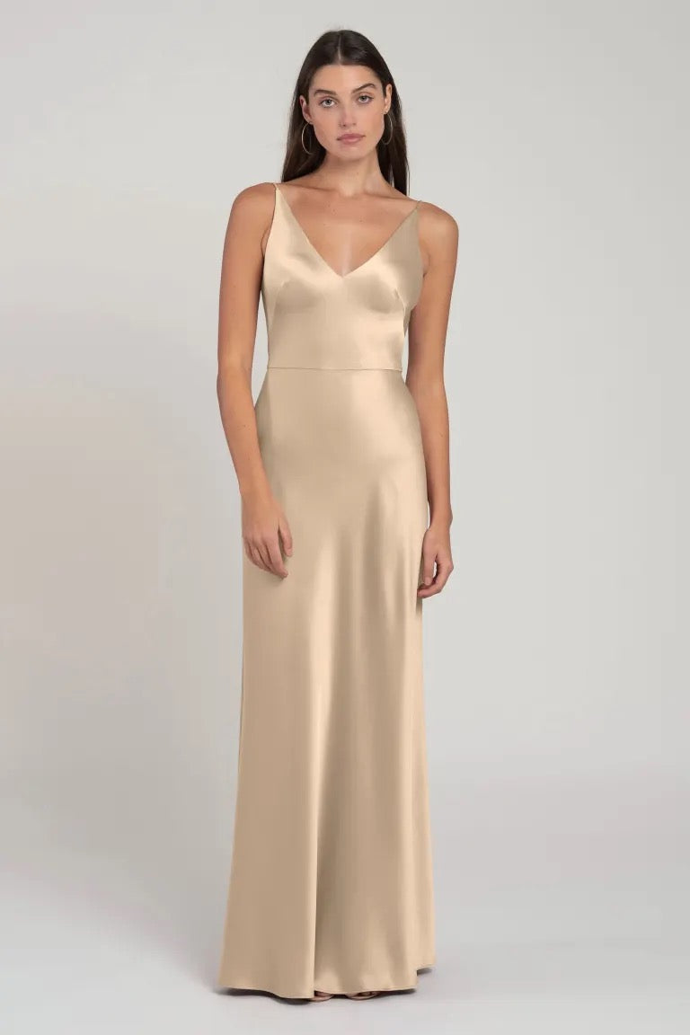 Woman posing in a simple, elegant beige satin Marla bridesmaid dress by Jenny Yoo from Bergamot Bridal.