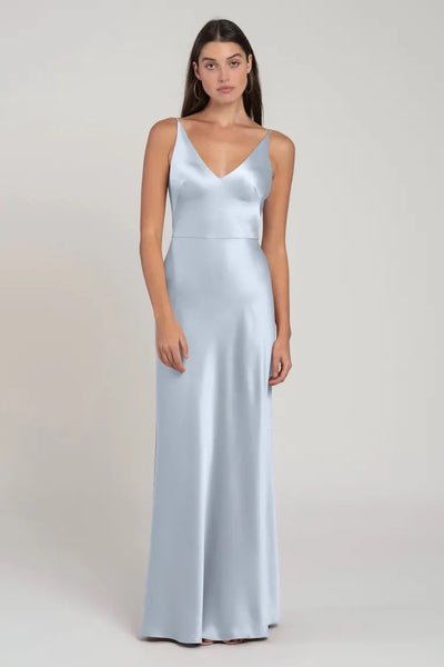 Woman in a sleek, satin light blue evening gown with a bias cut skirt, the Marla Bridesmaid Dress by Jenny Yoo from Bergamot Bridal.