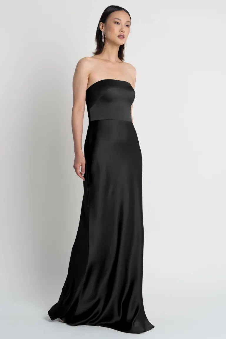 Woman in a strapless black Melody bridesmaid dress by Jenny Yoo with a bias-cut skirt from Bergamot Bridal.