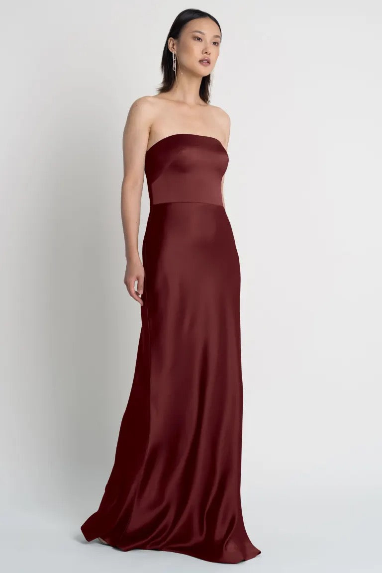Woman in a strapless neckline, maroon Melody - Bridesmaid Dress by Jenny Yoo evening gown from Bergamot Bridal.