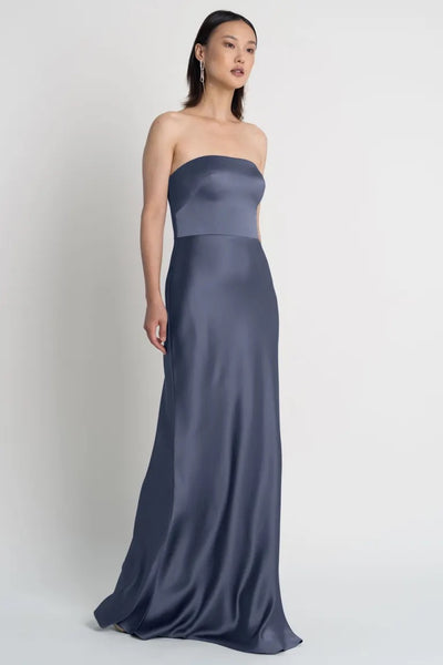 A woman wearing a strapless Melody - Bridesmaid Dress by Jenny Yoo satin evening gown from Bergamot Bridal.