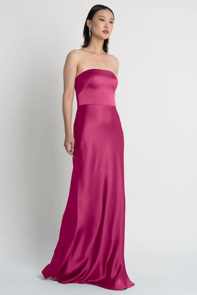 A woman in a Melody - Bridesmaid Dress by Jenny Yoo satin dress with a strapless neckline from Bergamot Bridal.