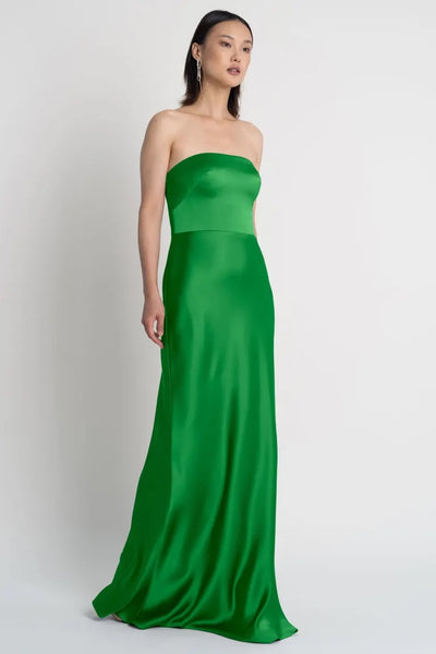 Woman in an elegant Melody bridesmaid dress by Jenny Yoo with a bias cut skirt and strapless neckline from Bergamot Bridal.