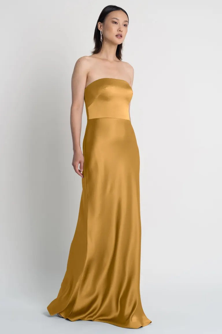 Woman in an elegant Melody Bridesmaid Dress by Jenny Yoo with a strapless neckline from Bergamot Bridal.