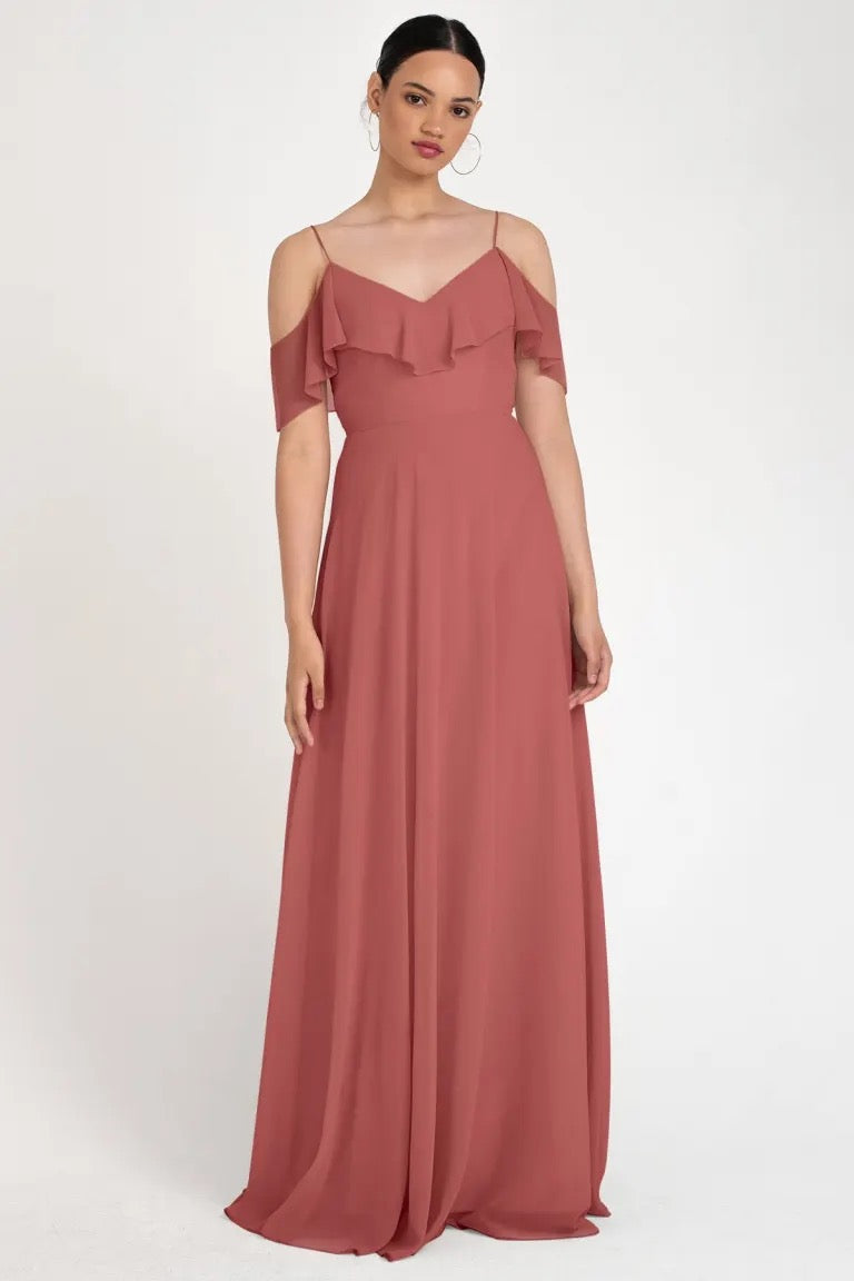 Woman in an elegant, off-the-shoulder terracotta Mila - Bridesmaid Dress by Jenny Yoo gown with a circle skirt from Bergamot Bridal.