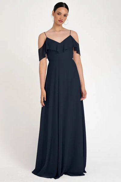 Woman modeling a navy off-the-shoulder evening gown with hoop earrings, the Mila - Bridesmaid Dress by Jenny Yoo from Bergamot Bridal.