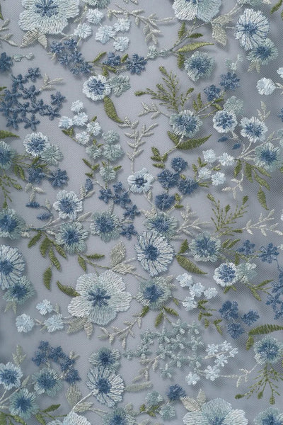 Close-up of a light blue Bergamot Bridal Rebecca - Jenny Yoo Bridesmaid Dress with delicate Ophelia embroidery in blue and green hues.