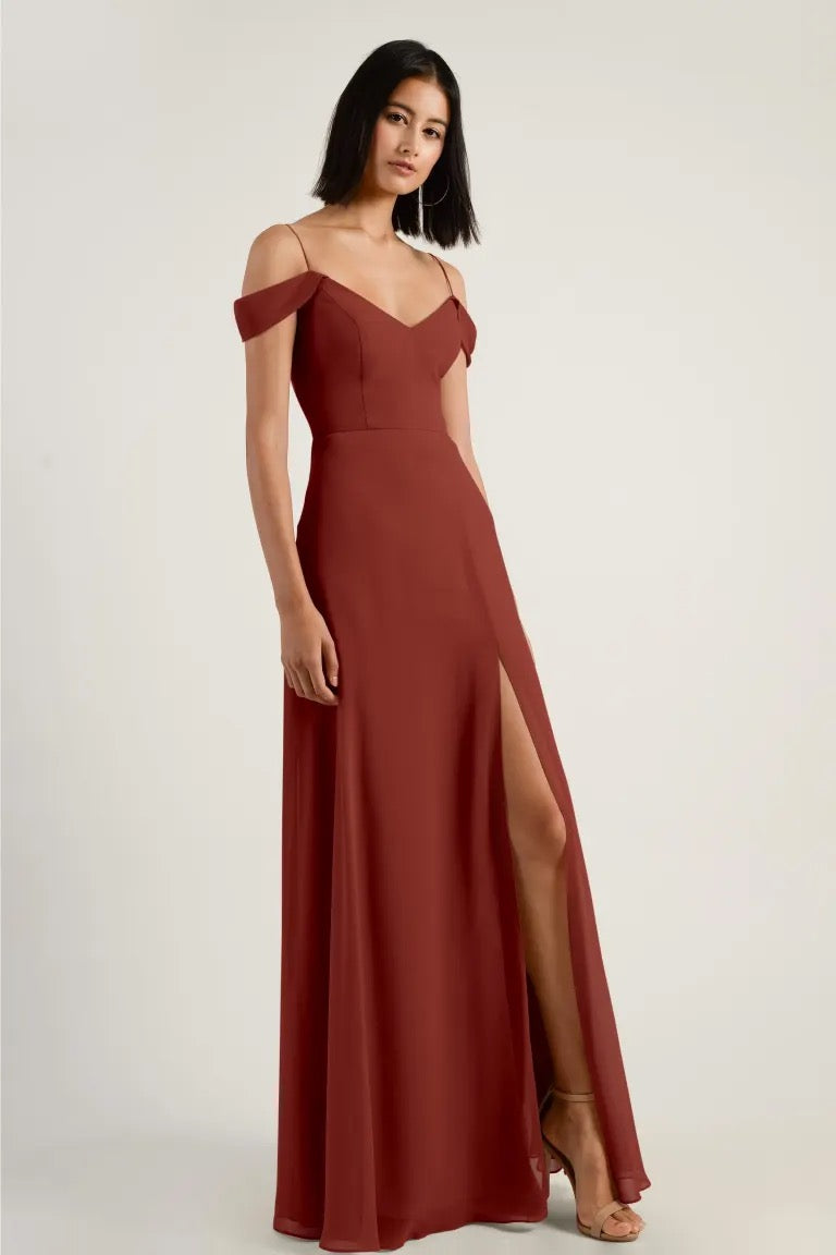 Woman in an elegant red dress with a high slit and Priya V-neck chiffon bridesmaid design by Jenny Yoo from Bergamot Bridal.