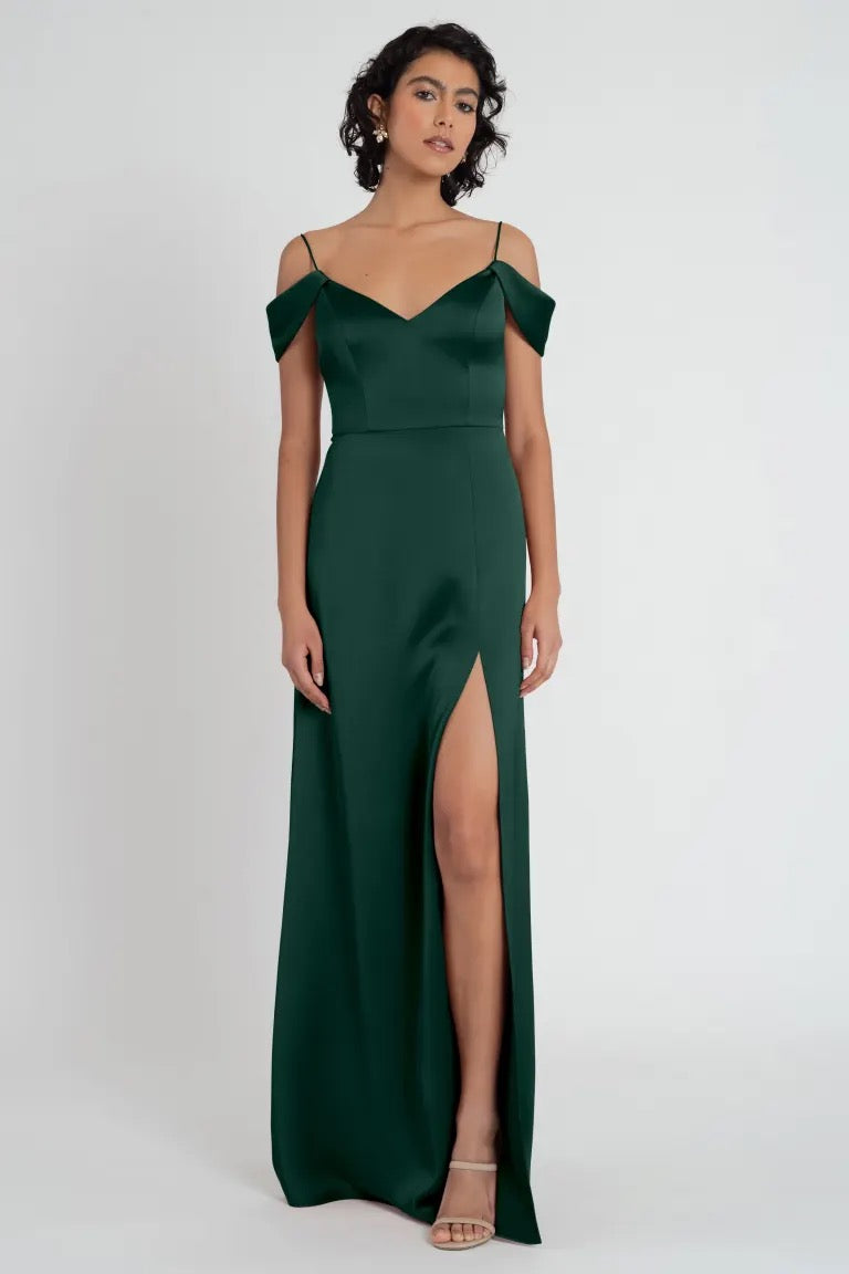 Woman in an elegant Priyanka - Bridesmaid Dress by Jenny Yoo with a slit and an off-the-shoulder sleeve from Bergamot Bridal.