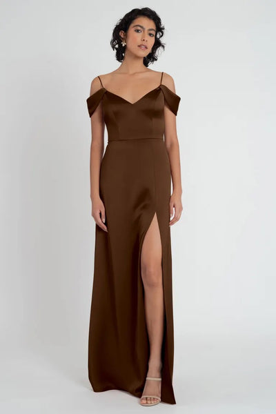 Woman posing in a brown satin Priyanka - Bridesmaid Dress by Jenny Yoo evening gown with a thigh-high slit from Bergamot Bridal.