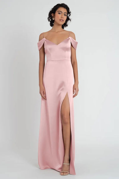 Woman posing in a pale pink satin V-neck Priyanka bridesmaid dress by Jenny Yoo with a side slit from Bergamot Bridal.