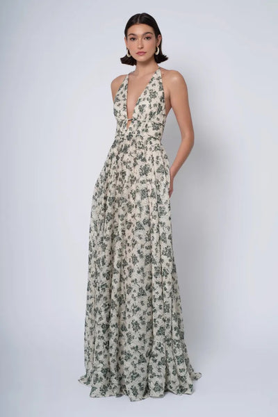 Woman in an elegant Jenny Yoo Bridesmaid Dress with a wildflowers print standing against a plain background, from Bergamot Bridal.