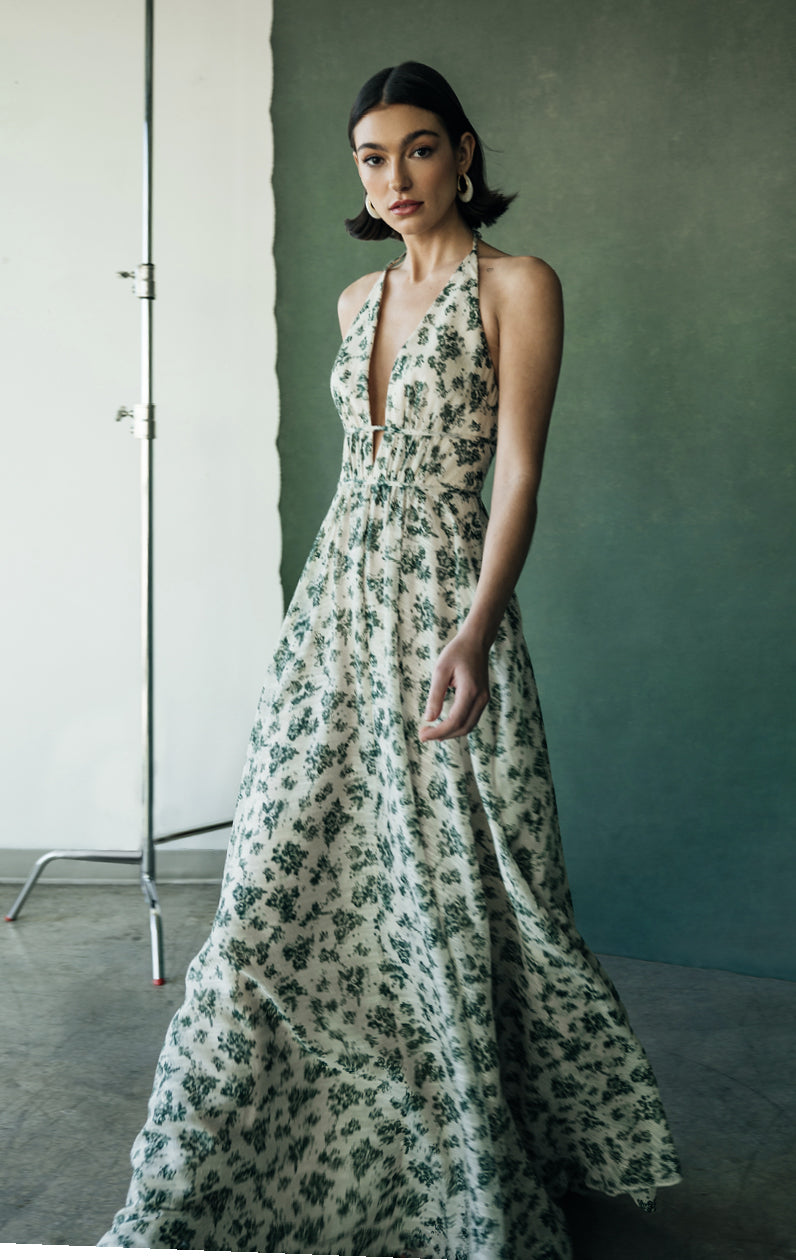 Woman in a chiffon wildflowers halter neckline Robin - Jenny Yoo Bridesmaid Dress posing in a studio setting from Bergamot Bridal.