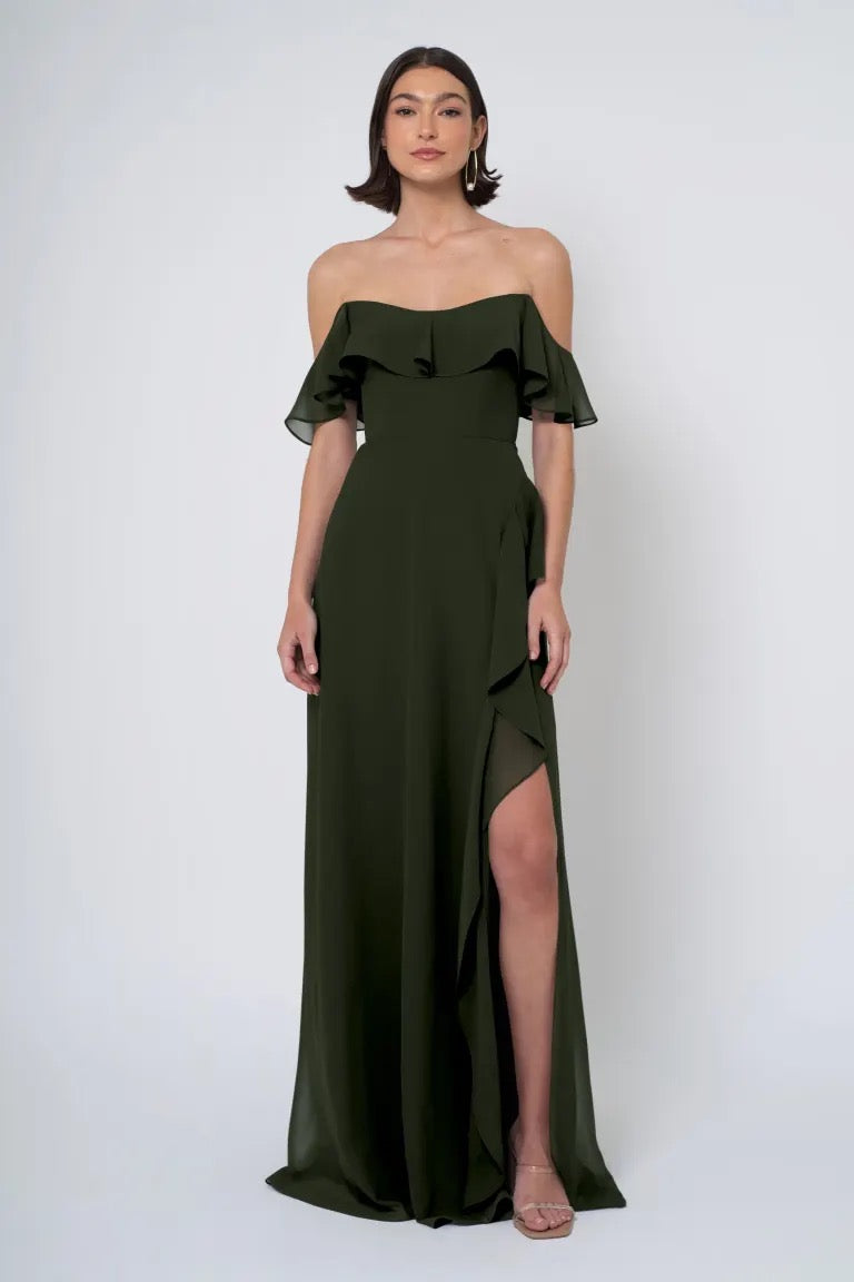 Woman in an elegant off-the-shoulder Salma chiffon Jenny Yoo Bridesmaid Dress with a side slit from Bergamot Bridal.