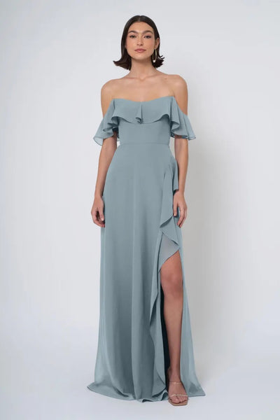 Woman in an elegant, off-the-shoulder, Salma chiffon dress with a side slit by Bergamot Bridal.