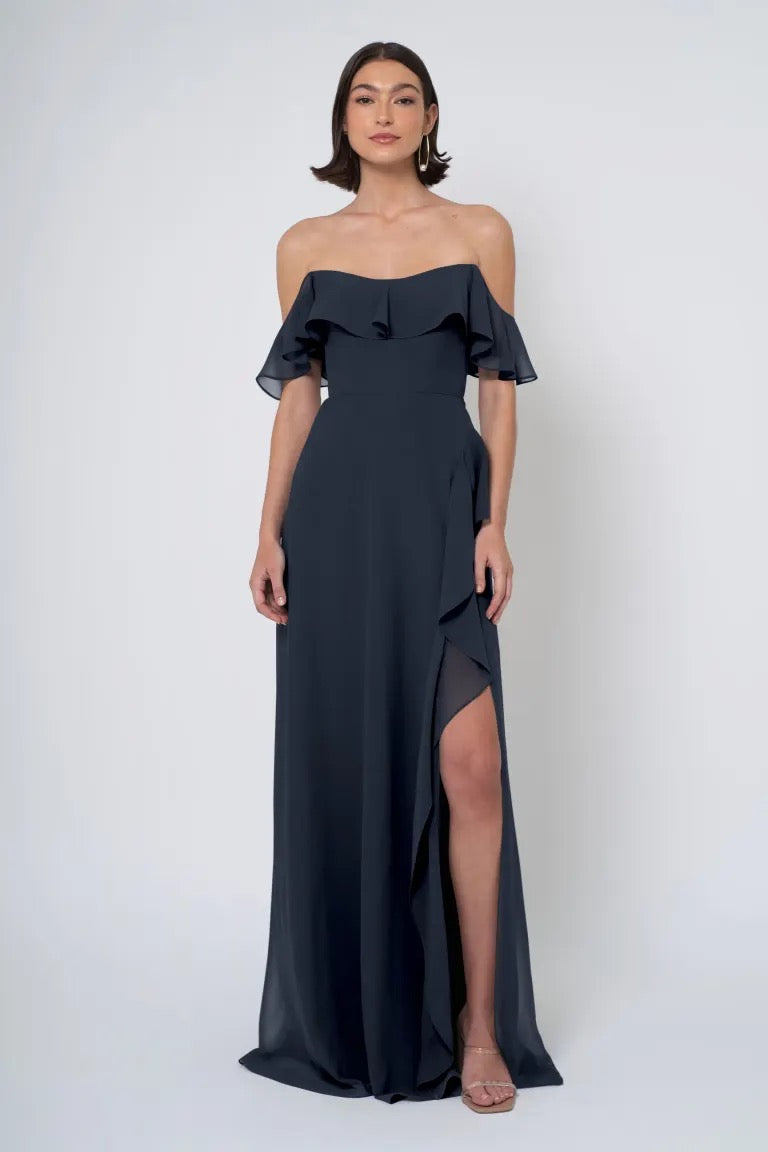 Woman in an elegant Salma - Jenny Yoo Bridesmaid Dress chiffon dress with a side slit from Bergamot Bridal.