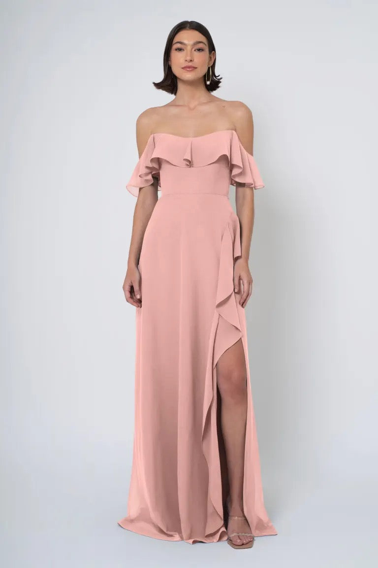 Woman wearing a pastel pink Salma - Jenny Yoo Bridesmaid Dress with an off the shoulder neckline and a side slit from Bergamot Bridal.